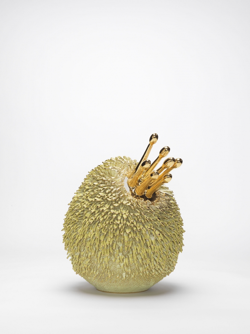 Green and yellow porcelain sculpture with gold accents by the artists the haas brothers