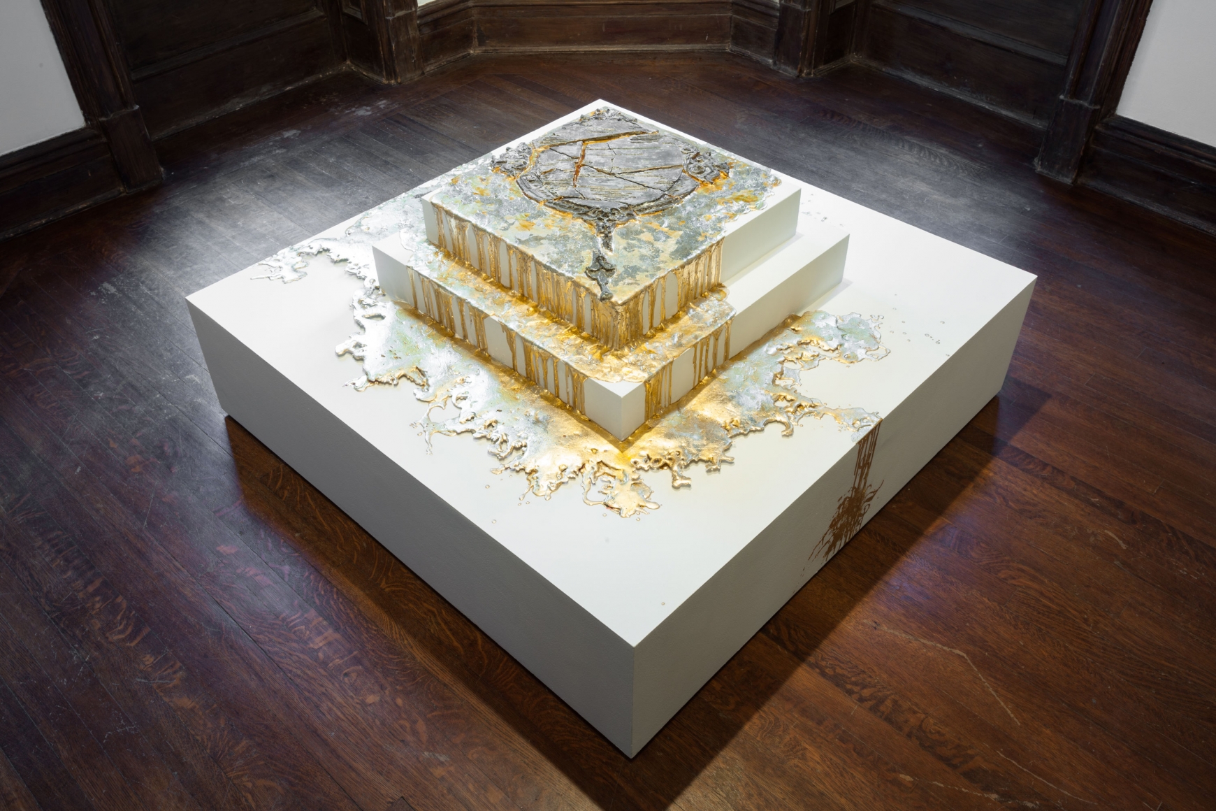 white multi-stepped sculpture with gold paint drip by diana al-hadid