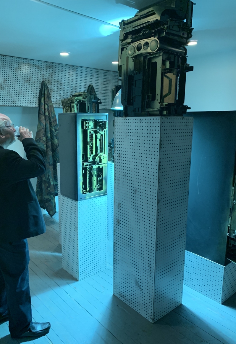 Upstairs exhibition room - Exhibiting five assemblage sculptures on pegboard pedestals- various sizes. Sculptures were placed surrounding a condensed 400-watt sulfur lamp, low hanging with a loud buzzing sound. Phil Wagner, "Obsolescence"- opening evening.