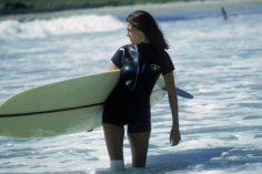 Slim Aarons, Minnie Cushing, September 1965: American society girl Minnie Cushing carries her surfboard under her arm