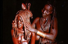 Carol Beckwith and Angela Fisher, Himba bride is prepared for marriage by her mother wearing an ekori headdress, Namibia
