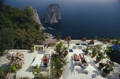 Slim Aarons, Il Canille, 1980: Sunbathers lounge on the terrace of Il Canille, built into the rocks of Pizzolungo overlooking the waters off the coast of Capri, Italy