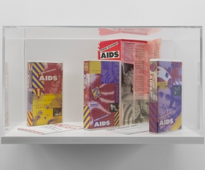 A vitrine that contains 2 tapes and a program for the "Video Against AIDS" program