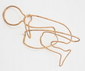 An outline made of thin plywood of a person huddling, mounted on the wall