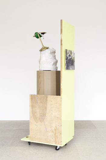 Rachel Harrison, The Fourth Shade, 2000, Wood, polystyrene, cement, acrylic, cardboard, hollow core door, lamp, wheels, and chromogenic print, 85 x 32 x 24 inches