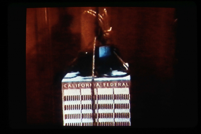Julie Becker’s Federal Building with Music, 2002 , DVD, projector screen and wood bench