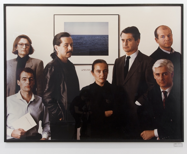 Hommage à Philippe Thomas. Autoportrait en groupe, 1985 1 color photograph and title card with text: “Hommage à Philippe Thomas Autoportrait en groupe 1985” Photo: 60 1/4 x 78 3/4 inches (153 x 200 cm) Title card: 1 5/8 x 3 7/8 inches (4 x 10 cm) Collection of Daniel Bosser, Paris