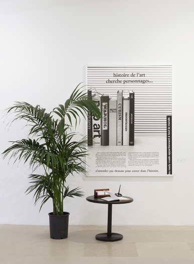 readymades belong to everyone® La pétition de principe (The petition of principle), 1988 Black and white photograph, palm tree, pedestal table, visitor's book, pen and penholder, display stand for calling cards bearing the name of the agency les ready-made appartiennent à tout le monde, 32 rue de Lappe, 75011 Paris, (01) 43 55 36 90 / (01) 48 06 15 76; title card with text: "La pétition de principe 1988" Photograph: 68 1//8 x 48 3/8 inches (173 x 123 cm) Pedestal table: 19 5/8 x 23 5/8 x 23 5/8 inches (50 x 60 x 60 cm) Title card: 1 7/8 x 4 3/8 inches (4.9 x 11 cm) (RBE.002)