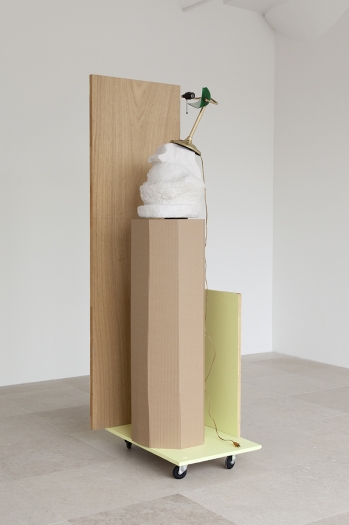 Rachel Harrison, The Fourth Shade, 2000, Wood, polystyrene, cement, acrylic, cardboard, hollow core door, lamp, wheels, and chromogenic print, 85 x 32 x 24 inches