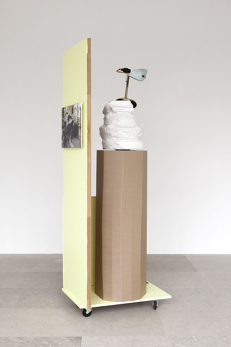Rachel Harrison, The Fourth Shade, 2000, Wood, polystyrene, cement, acrylic, cardboard, hollow core door, lamp, wheels, and chromogenic print, 85 x 32 x 24 inches