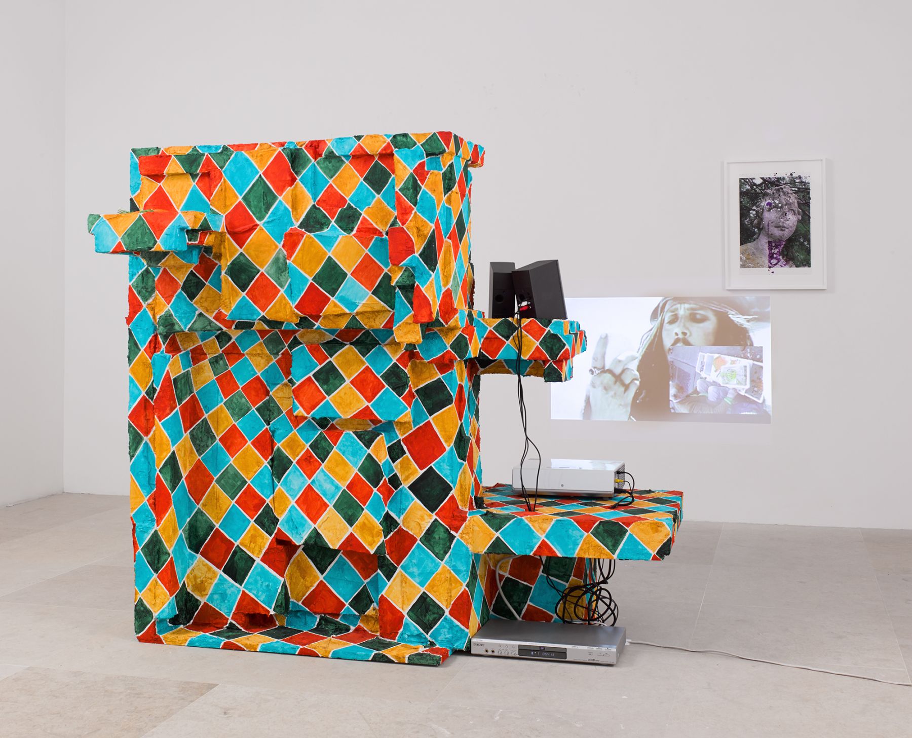Rachel Harrison Sops for Cerberus, 2008 Wood, polystyrene, cement, acrylic, fake carrots, projector, speakers, DVD player, framed mixed media inkjet print and Vanity Fare video, color/sound 62 x 67 x 31 inches; video 17:08 min. 157.5 x 170.2 x 78.7 cm; video 17:08 min. (RH.3502)