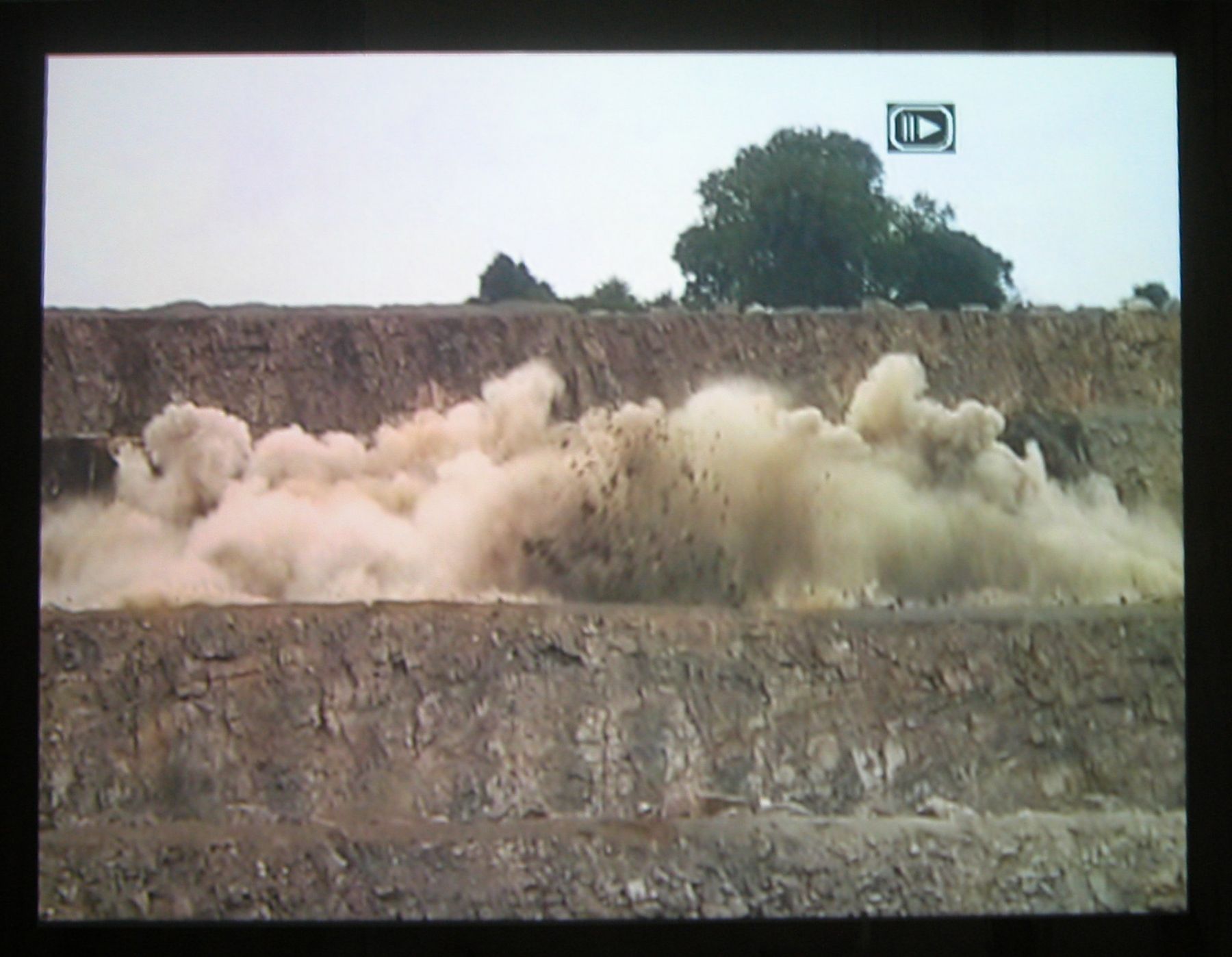 Quarry, 2003 (still), Two Parts: “Blast” (4 minutes), “Dr. Chris Alabaster” (12 minutes), 2 DVDs, bleachers, wooden screen, Installation dimensions variable