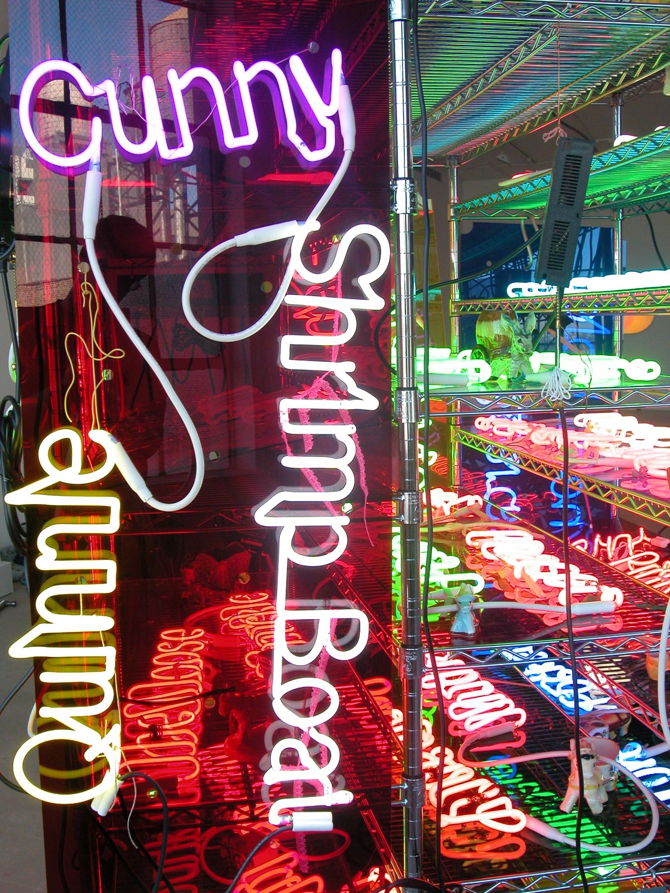 Jason Rhoades, Shelf (Love Pocket), 2003, Seville Ultra Durable chrome shelving system with 17 shelves, 23 neon panels, 41 ceramic donkey carts, 3 power strips, 3 orange extension cables, 14 metal hooks, 83 x 54 x 24 inches