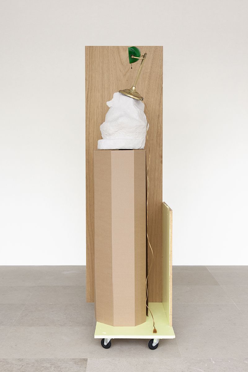 Rachel Harrison, The Fourth Shade, 200, Wood, polystyrene, cement, acrylic, cardboard, hollow core door, lamp, wheels, and chromogenic print, 85 x 32 x 24 inches