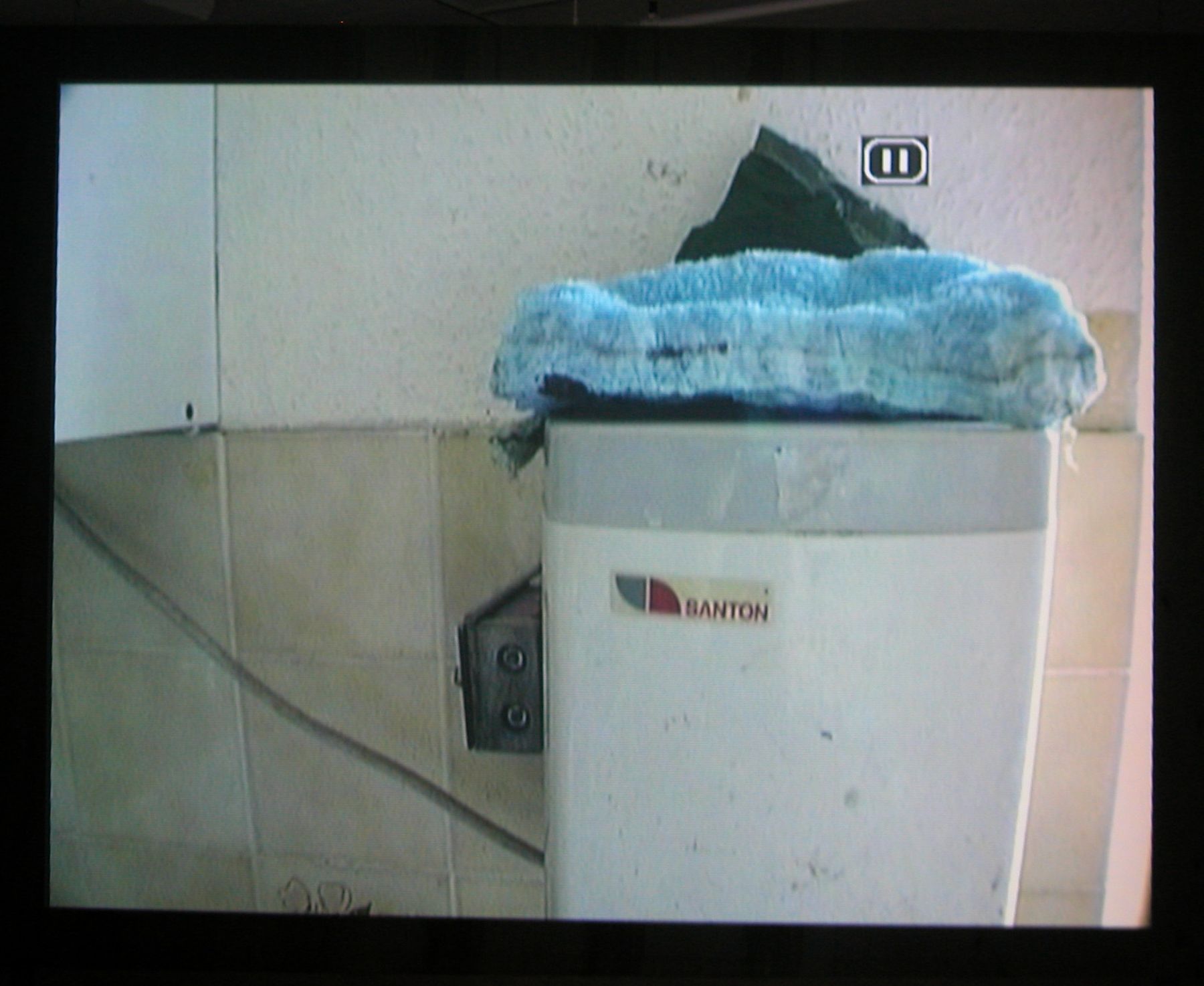 Quarry, 2003 (still), Two Parts: “Blast” (4 minutes), “Dr. Chris Alabaster” (12 minutes), 2 DVDs, bleachers, wooden screen, Installation dimensions variable