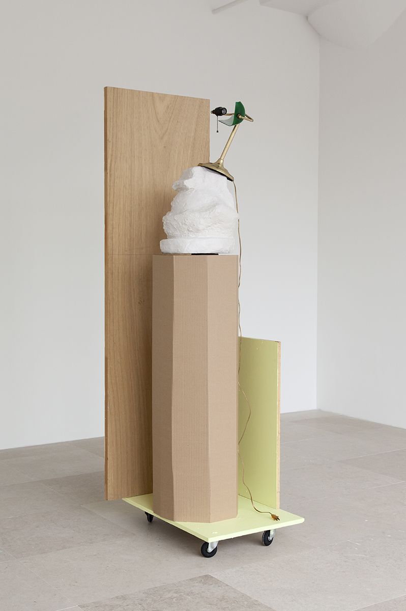 Rachel Harrison, The Fourth Shade, 2000, Wood, polystyrene, cement, acrylic, cardboard, hollow core door, lamp, wheels, and chromogenic print, 85 x 32 x 24 inches