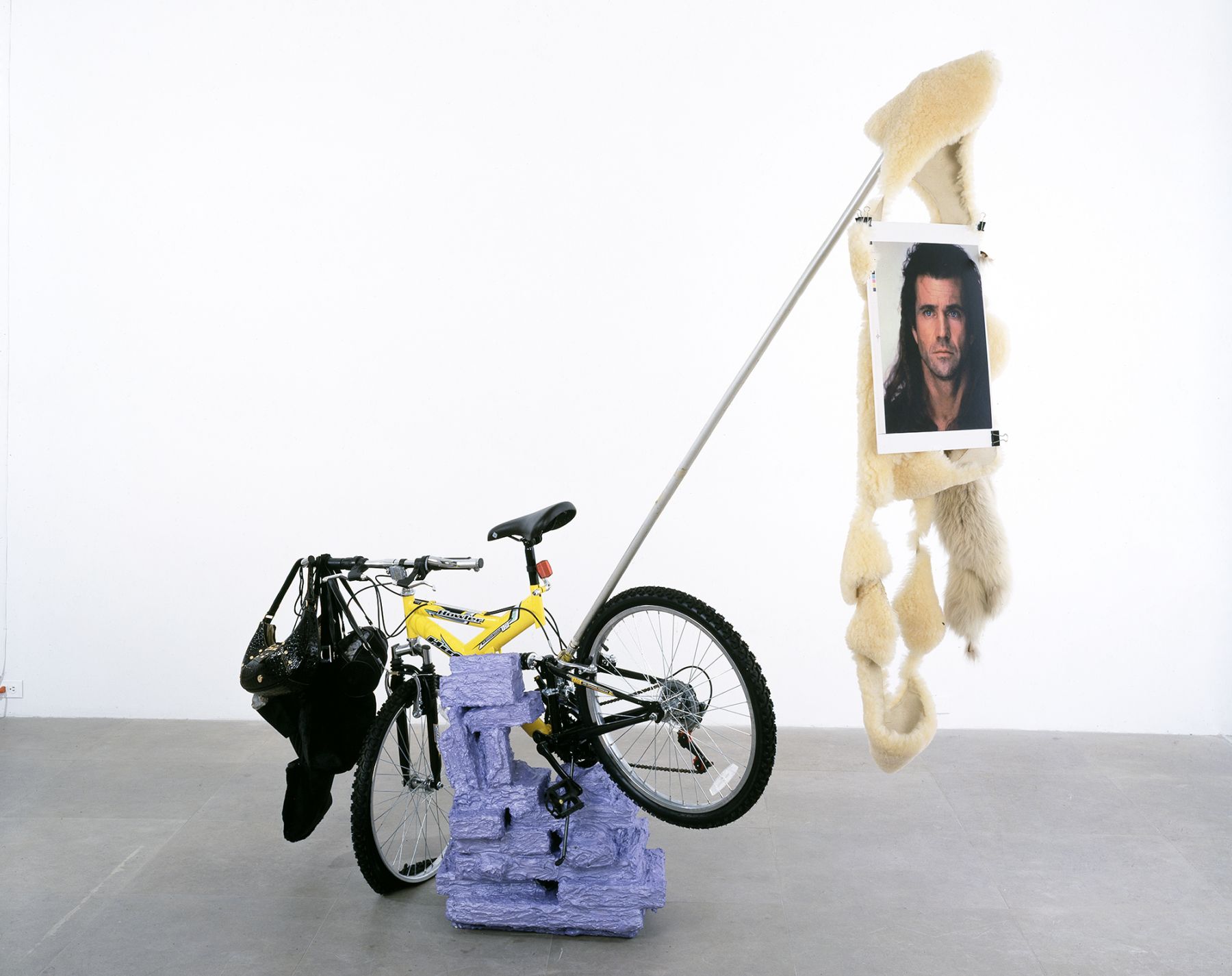Rachel Harrison Huffy Howler, 2004 Wood, polystyrene, cement, acrylic, Huffy Howler bicycle, handbags, rocks, brick, sheepskin fur, metal pole, wire, pigmented inkjet print, binder clips 84 x 84 x 30 inches (213.4 x 213.4 x 76.2 cm)