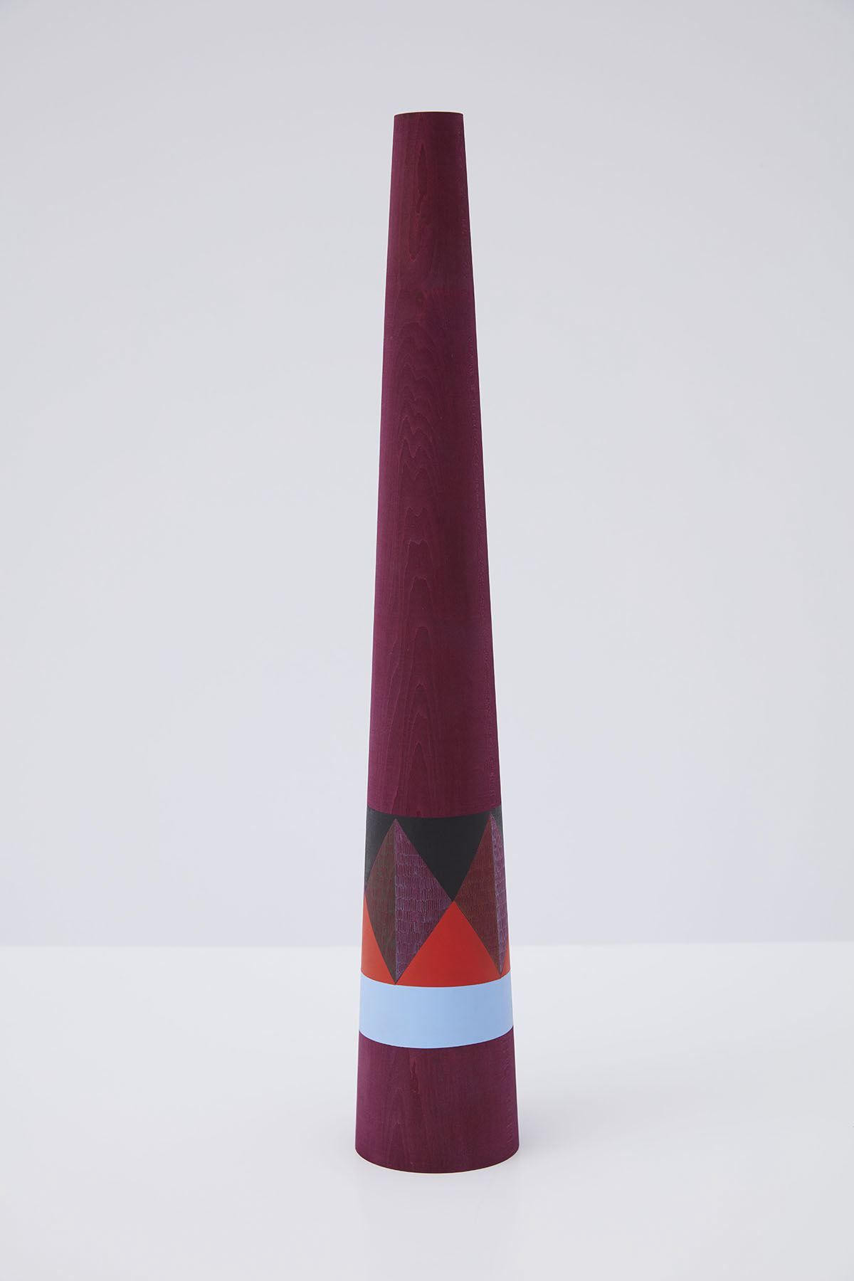 wooden sculpture with geometric shapes painted on it by claudia wieser