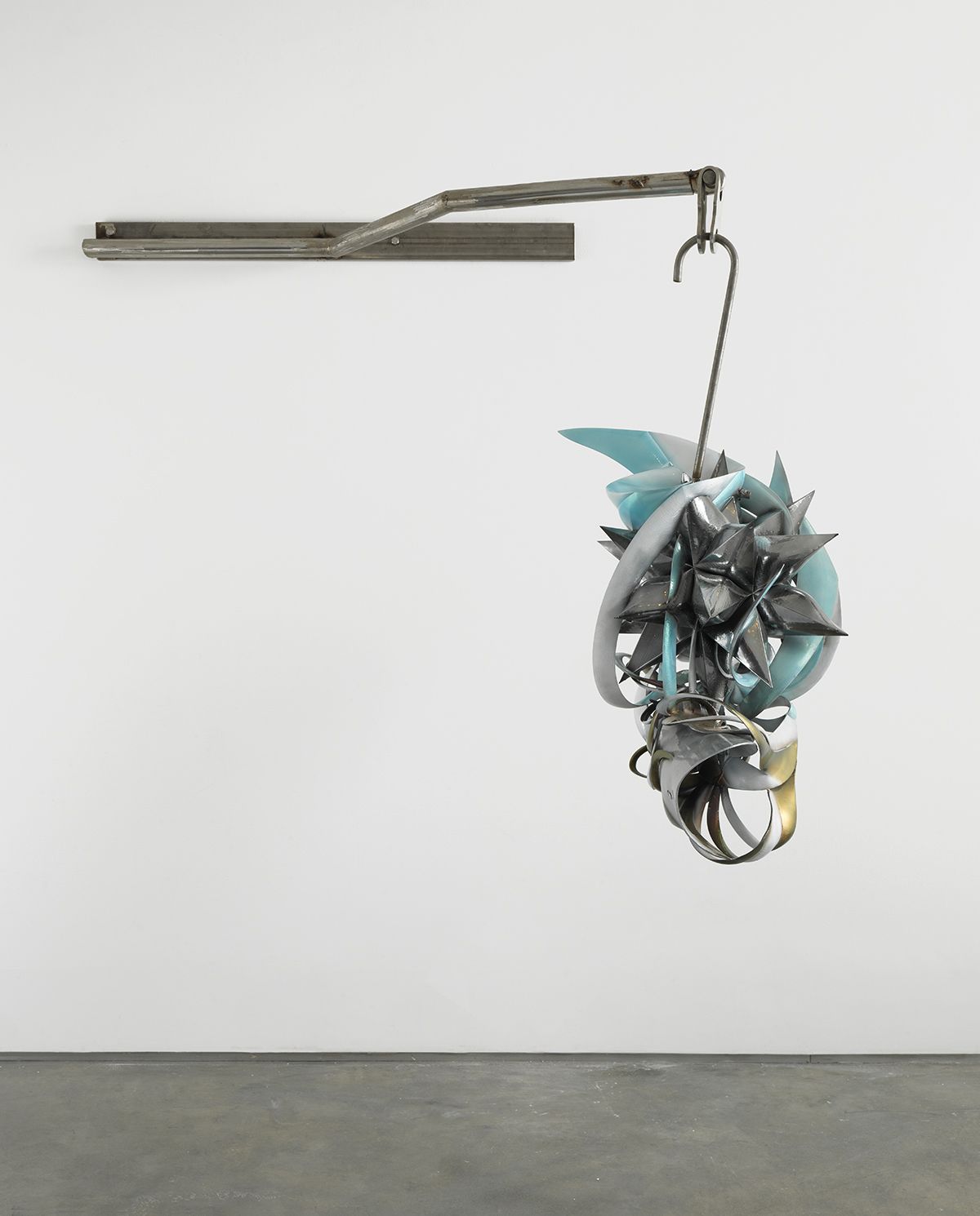 a hanging sculpture of twisted metal by frank stella exhibited in a downtown gallery