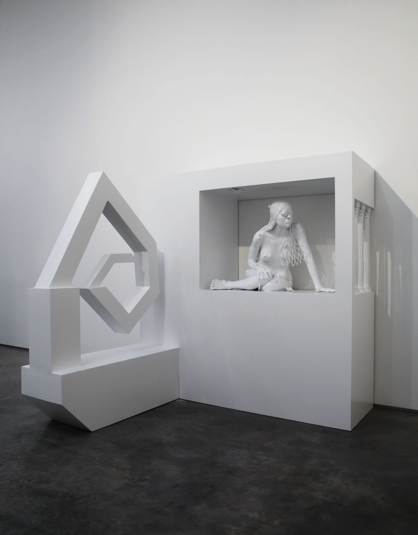 sculpture of a woman crouching in an enclosure by liz craft