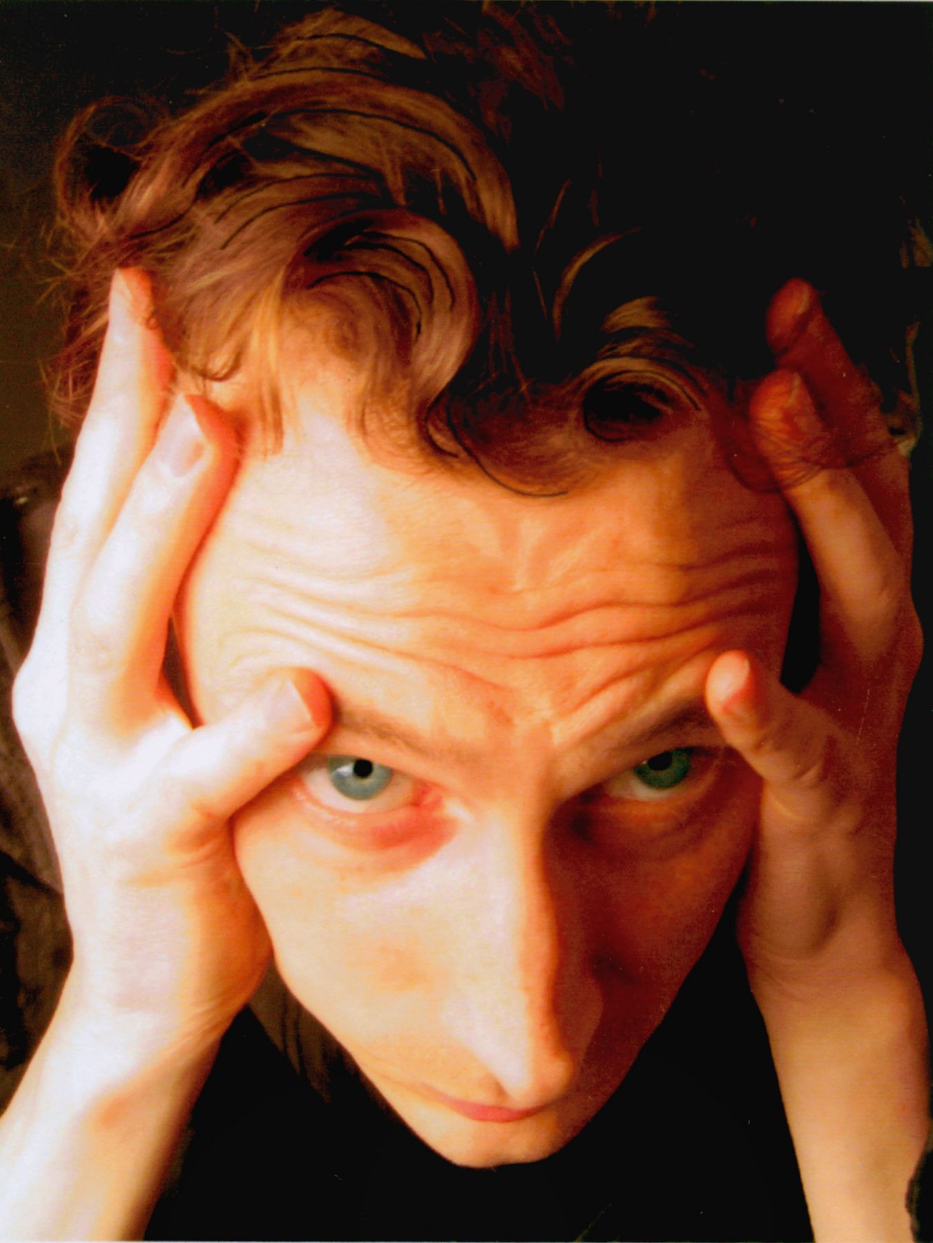 photograph of a man clutching his temples by jeffrey wells