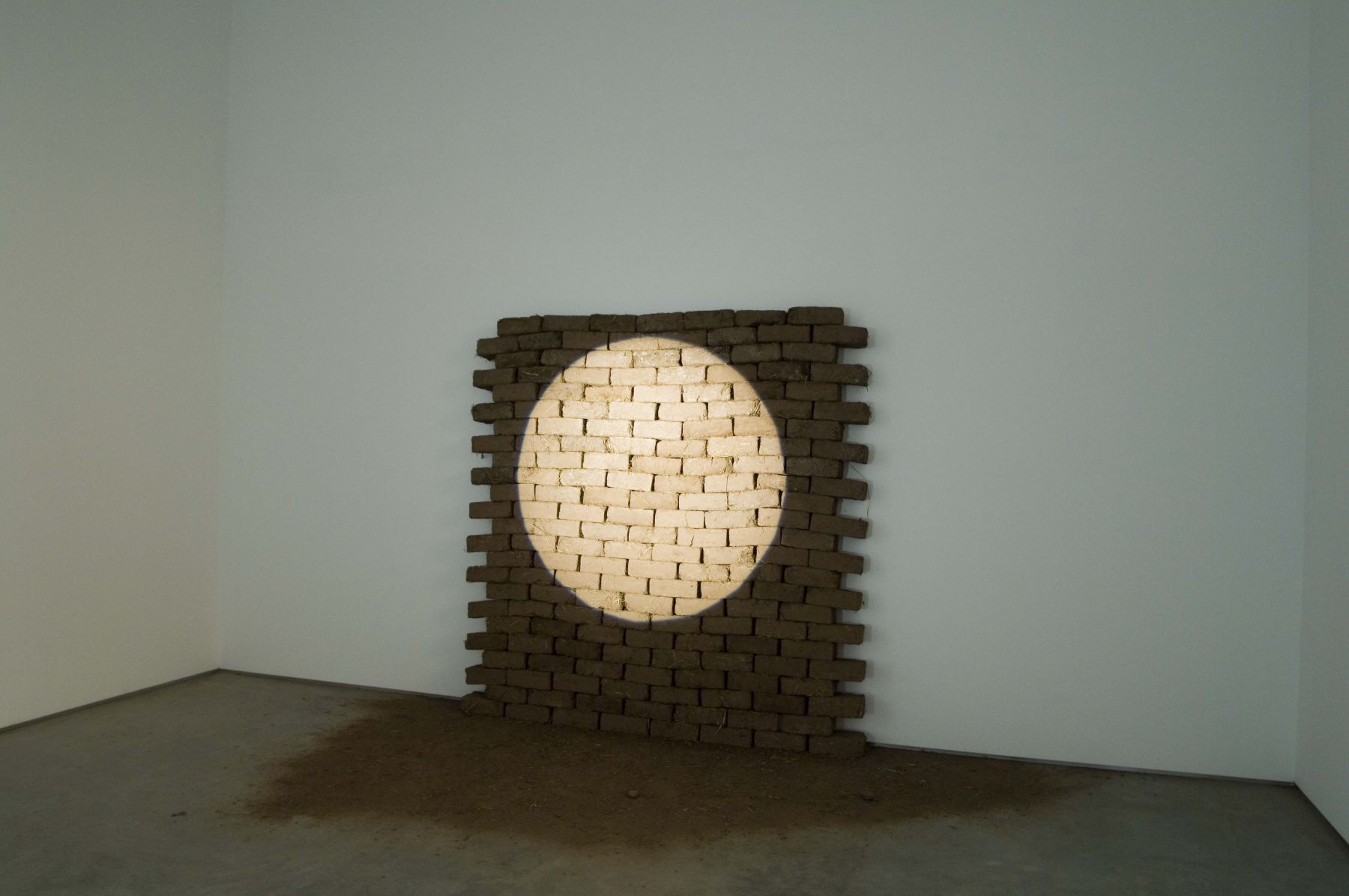 installation with bricks highlighted by a spotlight by christ moukarbel