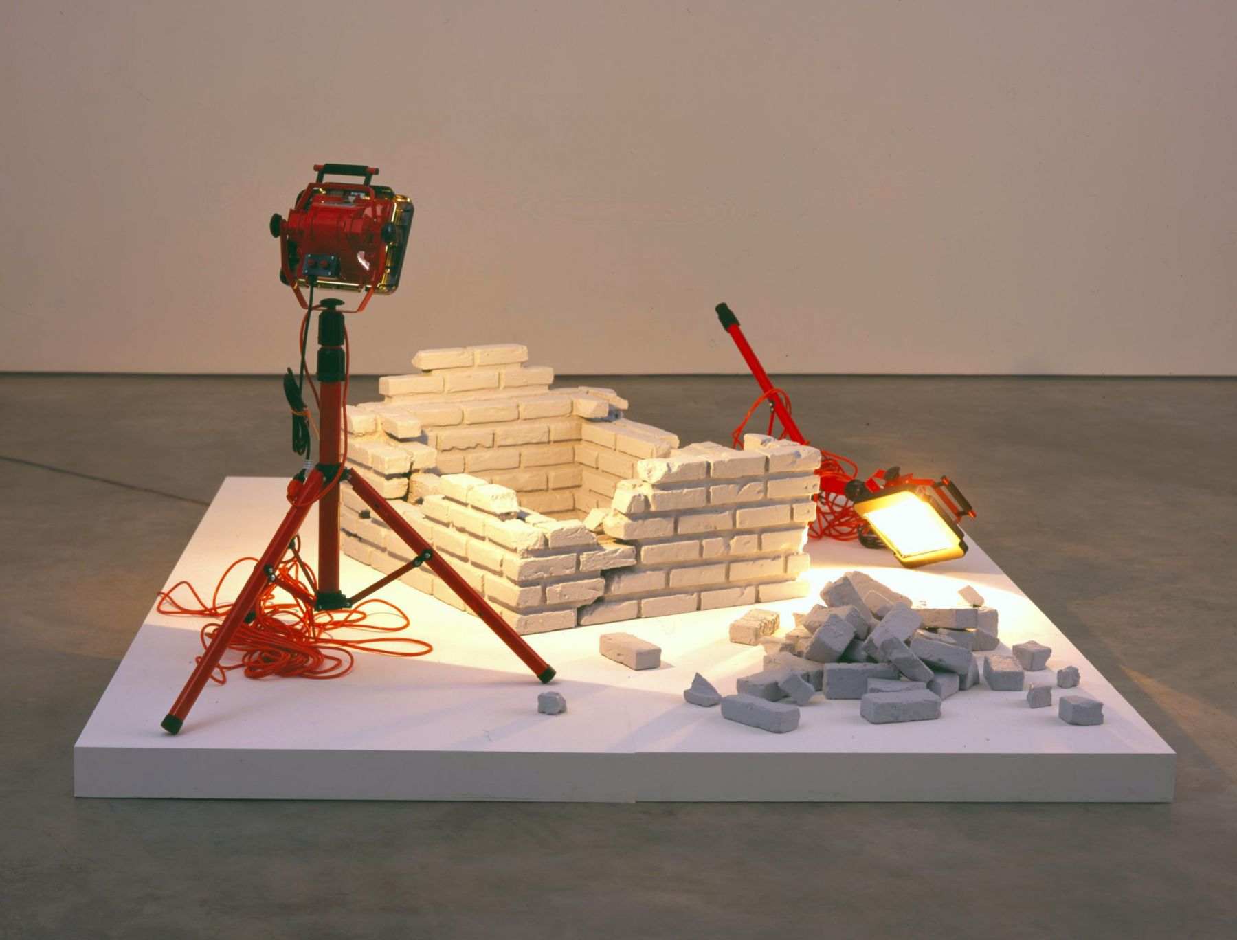 installation with bricks and a toppled work lamp by kon trubkovic