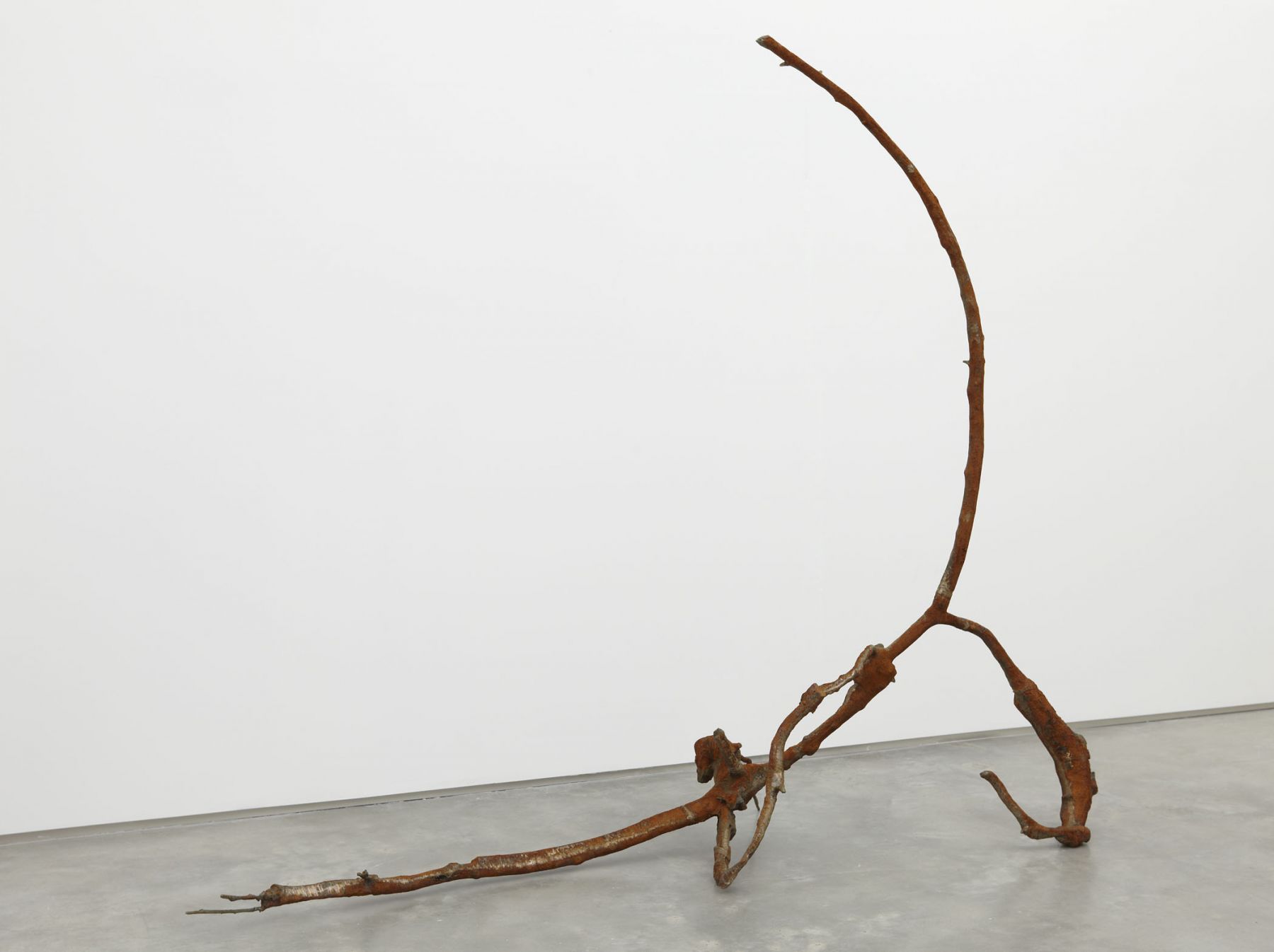 a rusted iron and bronze abstract sculpture by jay heikes exhibited in a nyc gallery