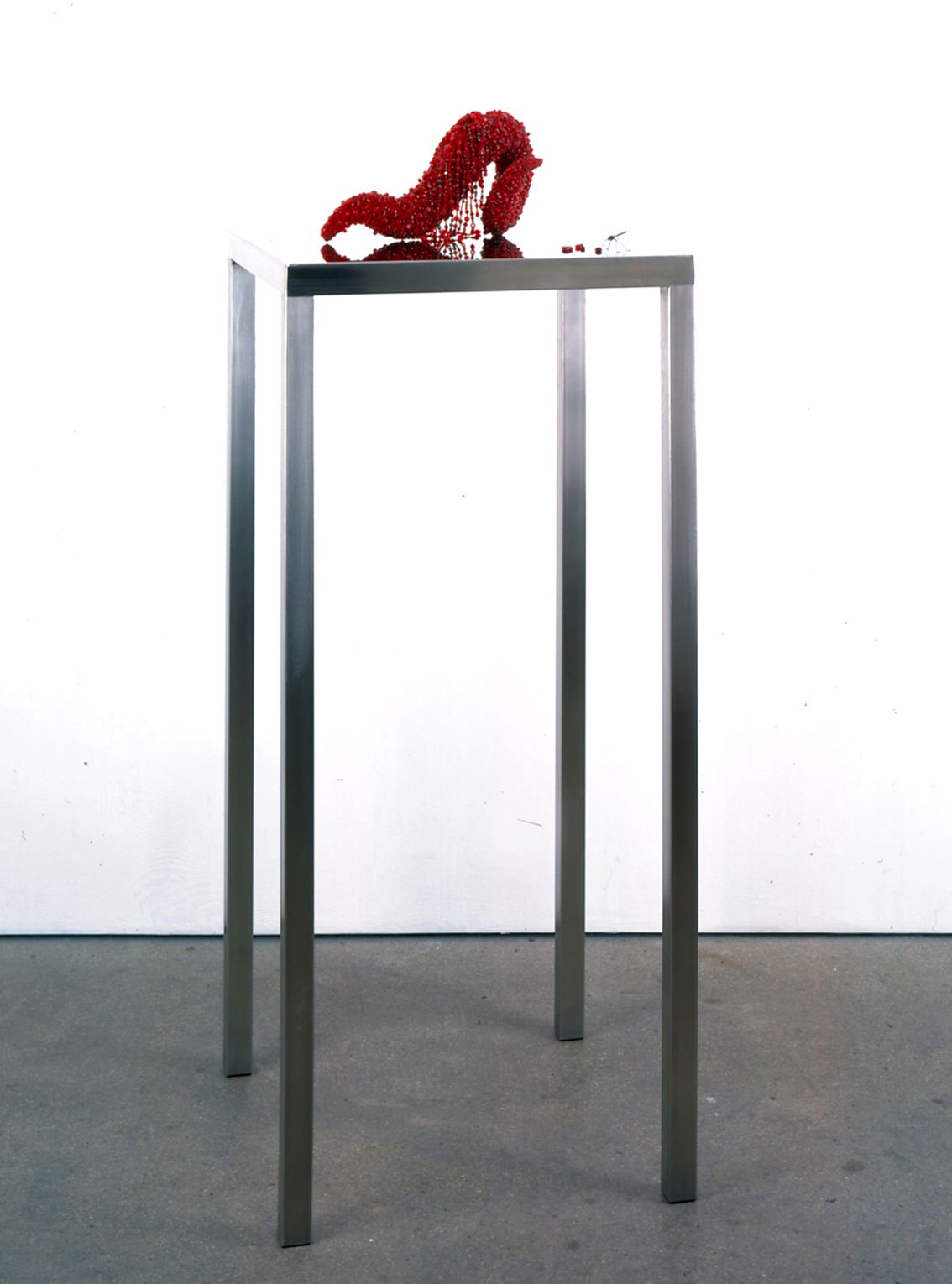 Black table with red sculpture by Angelo Filomeno