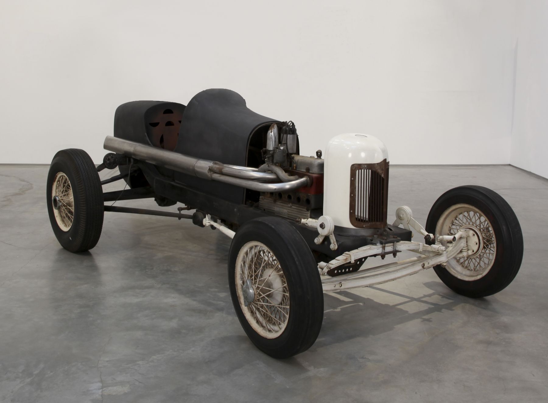 a race car by salvatore scarpitta exhibited in a contemporary art gallery