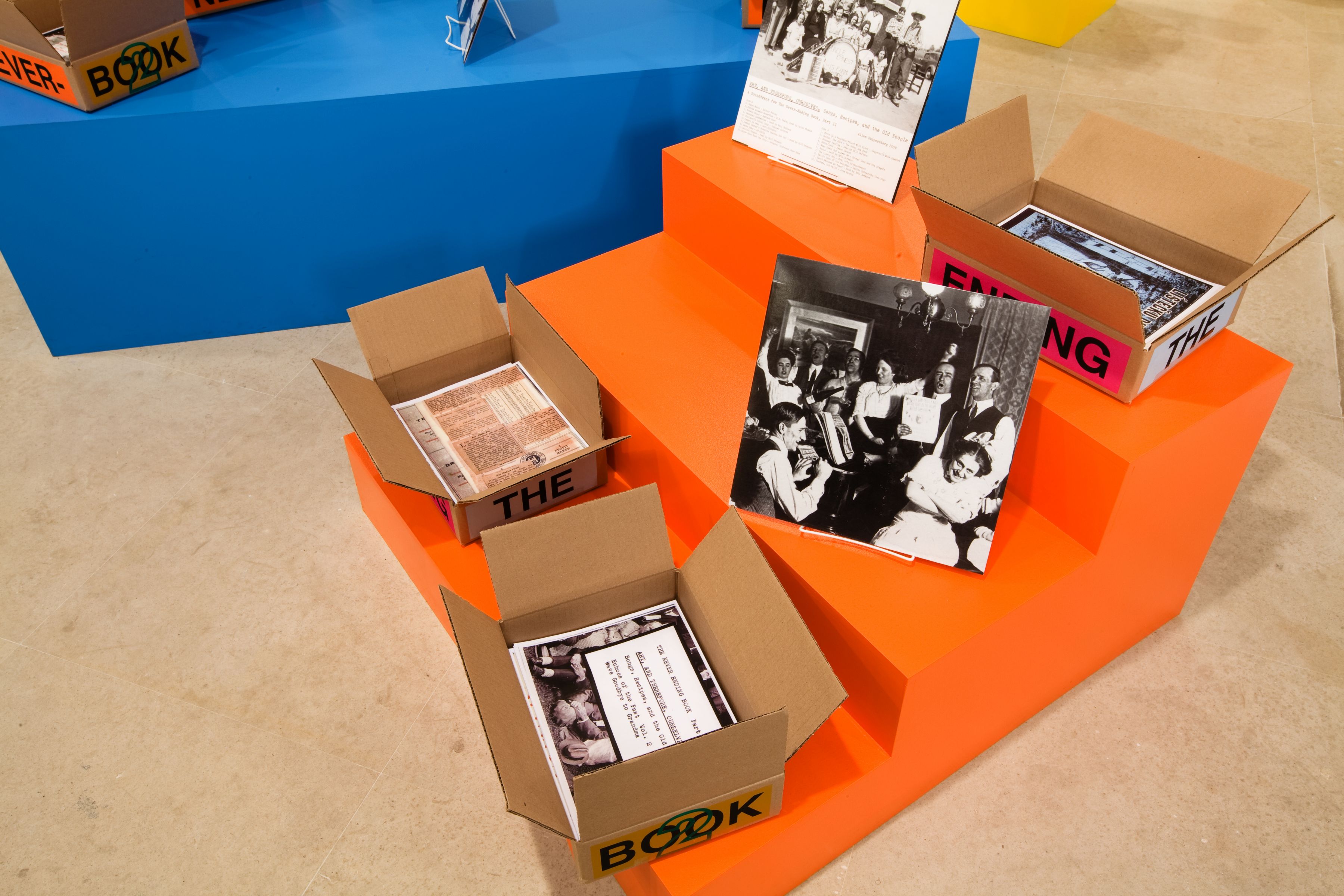 Allen Ruppersberg The Never Ending Book Part Two/Art and Therefore Ourselves 2009 color copies, cardboard boxes, artist's records 5 lightboxes banner letterpress posters and 17 furniture elements overall dimensions variable