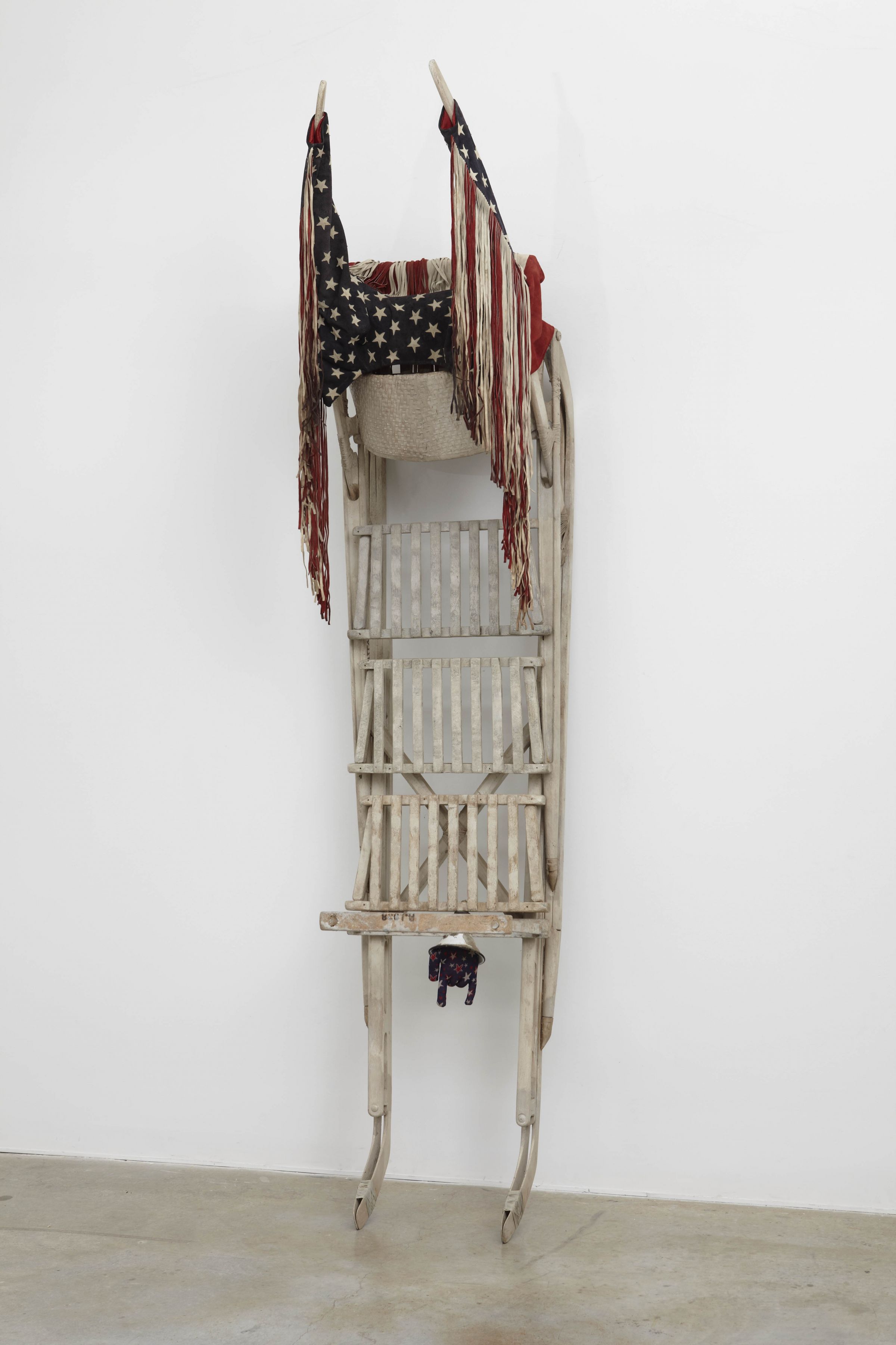 a sled with american flags by salvatore scarpitta on exhibition in a new york city gallery