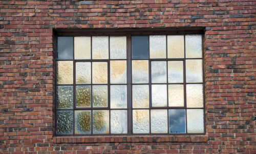 frosted glass window with black panes in brick building