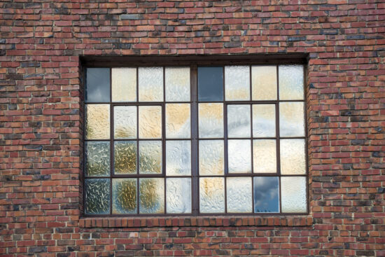 frosted glass window with black panes in brick building