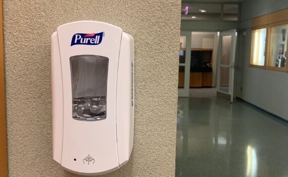 hand sanitizer dispenser on wall in a hallway