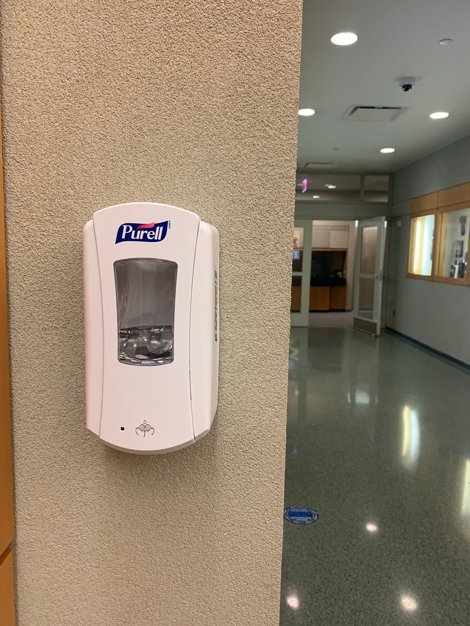 hand sanitizer dispenser on wall in a hallway