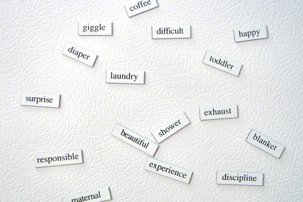 A collection of white magnets containing individual words in black typeface.