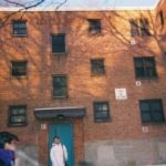 Two children standing in front of public housing building