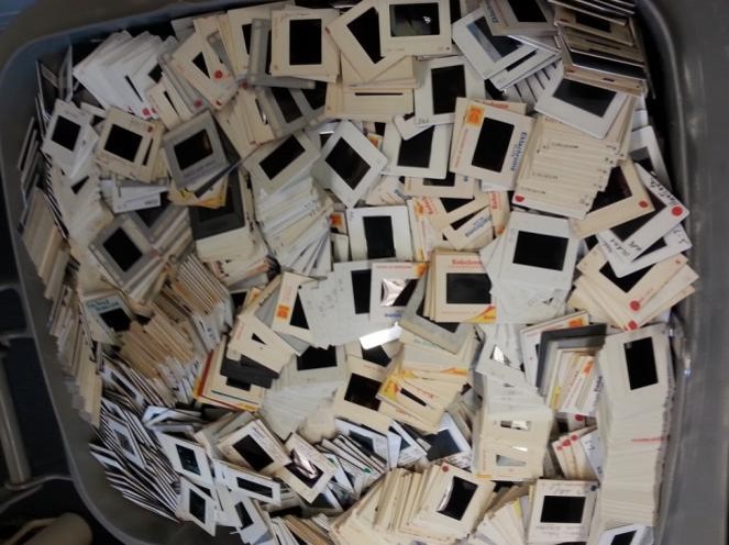 A messy pile of 35mm slides in a bin