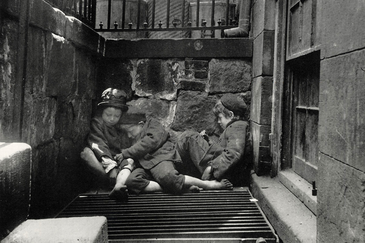 Black and white photograph depicting 3 children sleeping outside