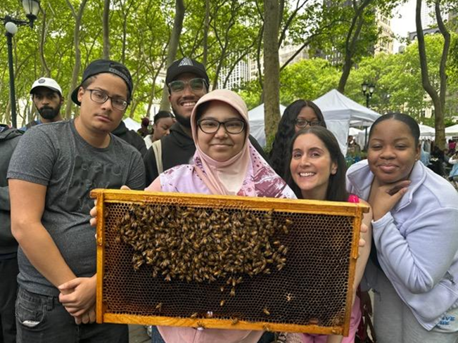 student holding up a beehive box