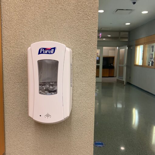 hand sanitizer dispenser on wall in a hallway