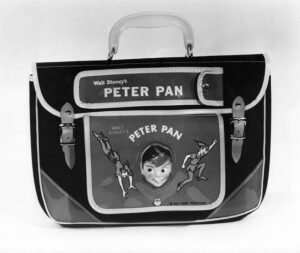 Shiny flap top briefcase style bag with clasps. Center flap has a cut out with three dimensional head of Peter Pan