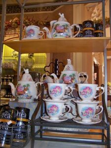 Shelves filled with Disney Alice themed tea merchandise including mugs, teapots, and tea