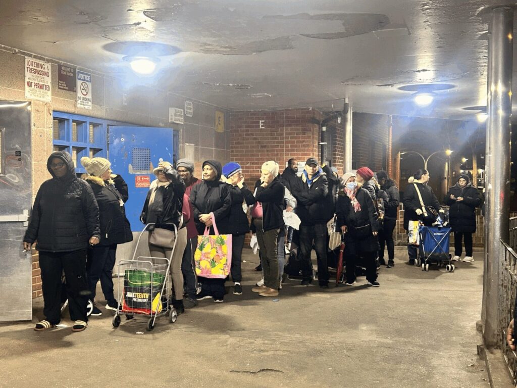 Residents wait in line to collect food pantry bags during a food distribution event. 