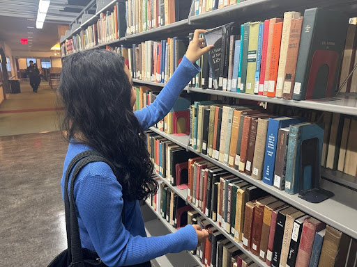 Sadie searches for a book in the Hunter College Library. (Photo credit: John Birt)