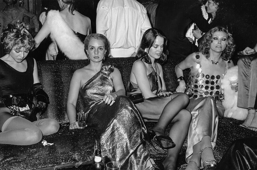 Spectacularly-dressed women take a load off at Studio 54.