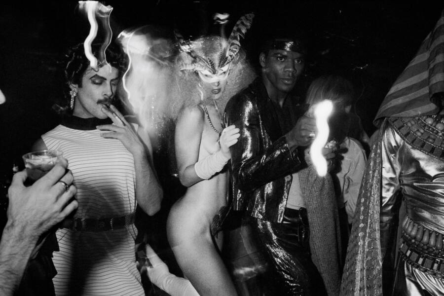 Two men and a naked woman dance together at Studio 54.