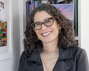 Kate Menken in front of a bookshelf.