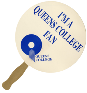 A round paper fan with a stick handle from the Queens College archives, featuring the old QC logo and the text: "I'm a Queens College Fan."
